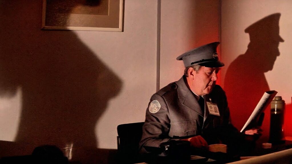 A Security Guard Immersed in Duty, Blind to the Approach of the Unclothed Alien Vampire Figure